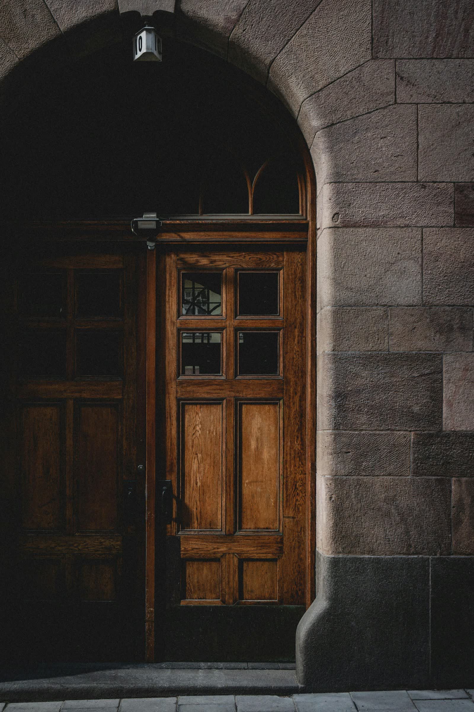 Puerta de madera de un edificio antiguo con fachada de piedra