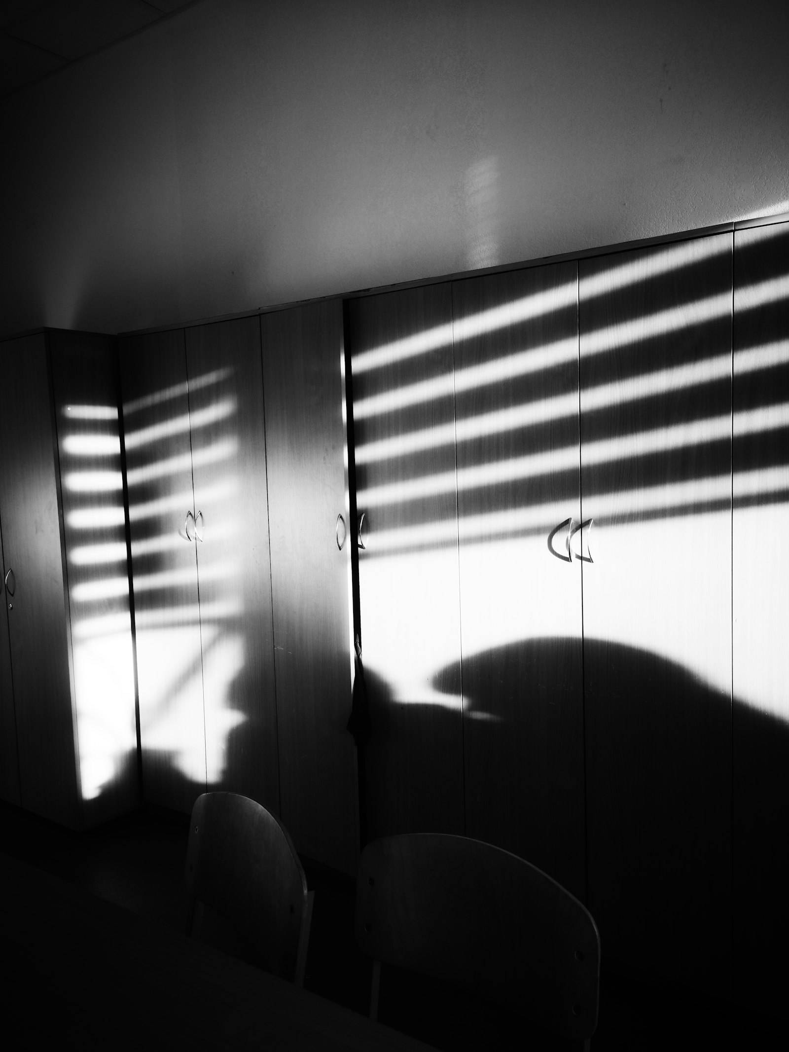 Sombras de una persiana sobre unos armarios